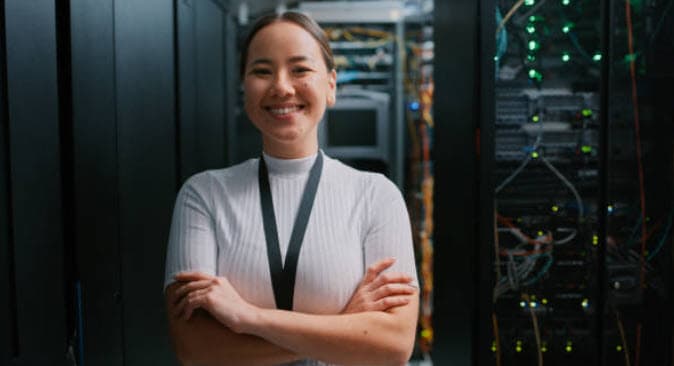 Smiling IT professional standing in a server room